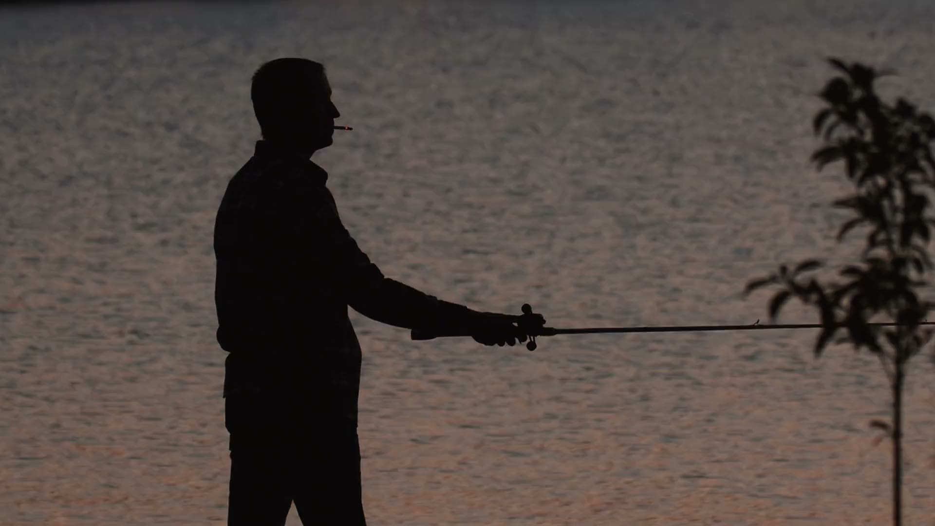 An angler casting into the river at dusk