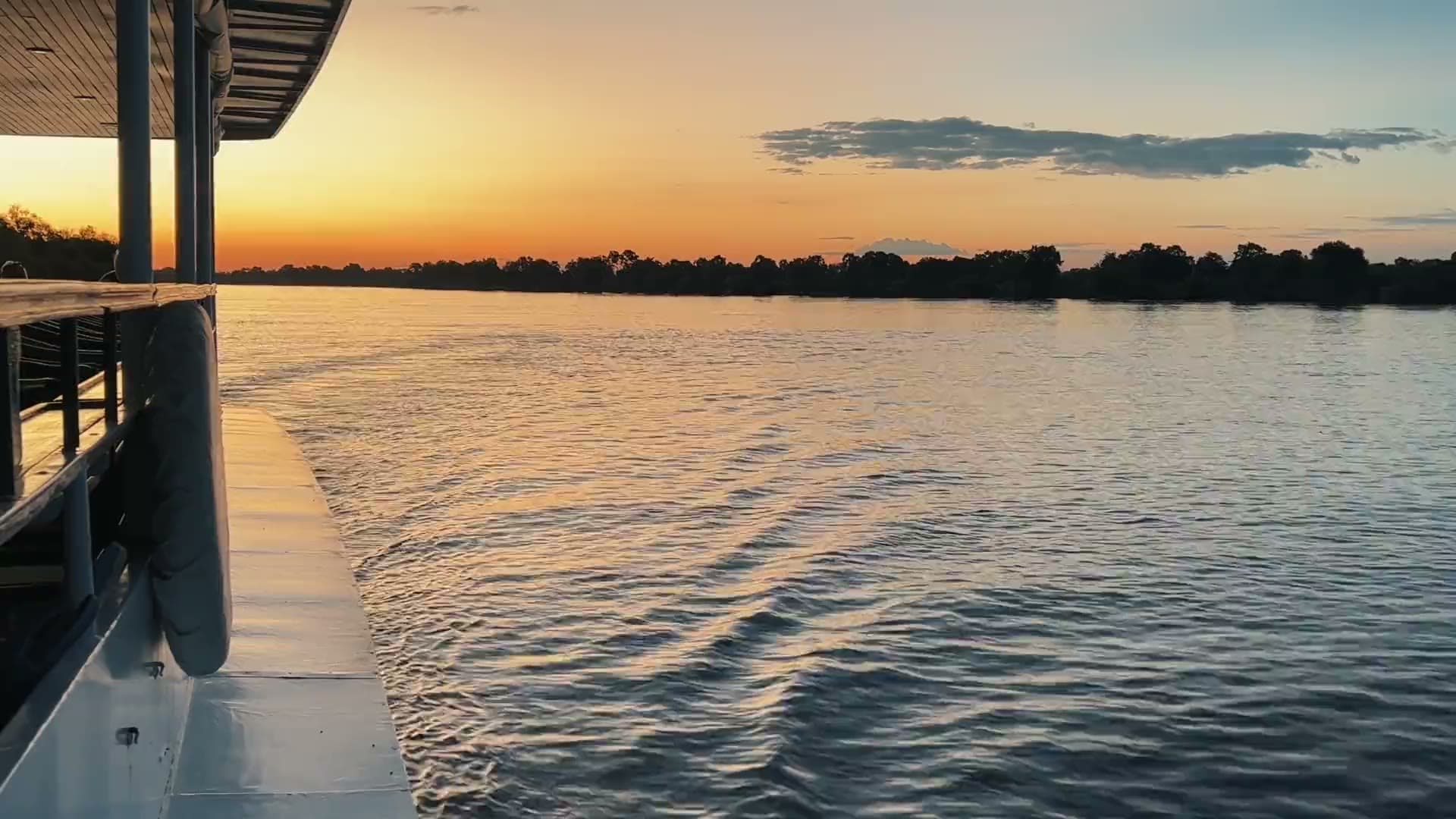 The view from a cruise boat deck as the sun sets over the Zambezi River
