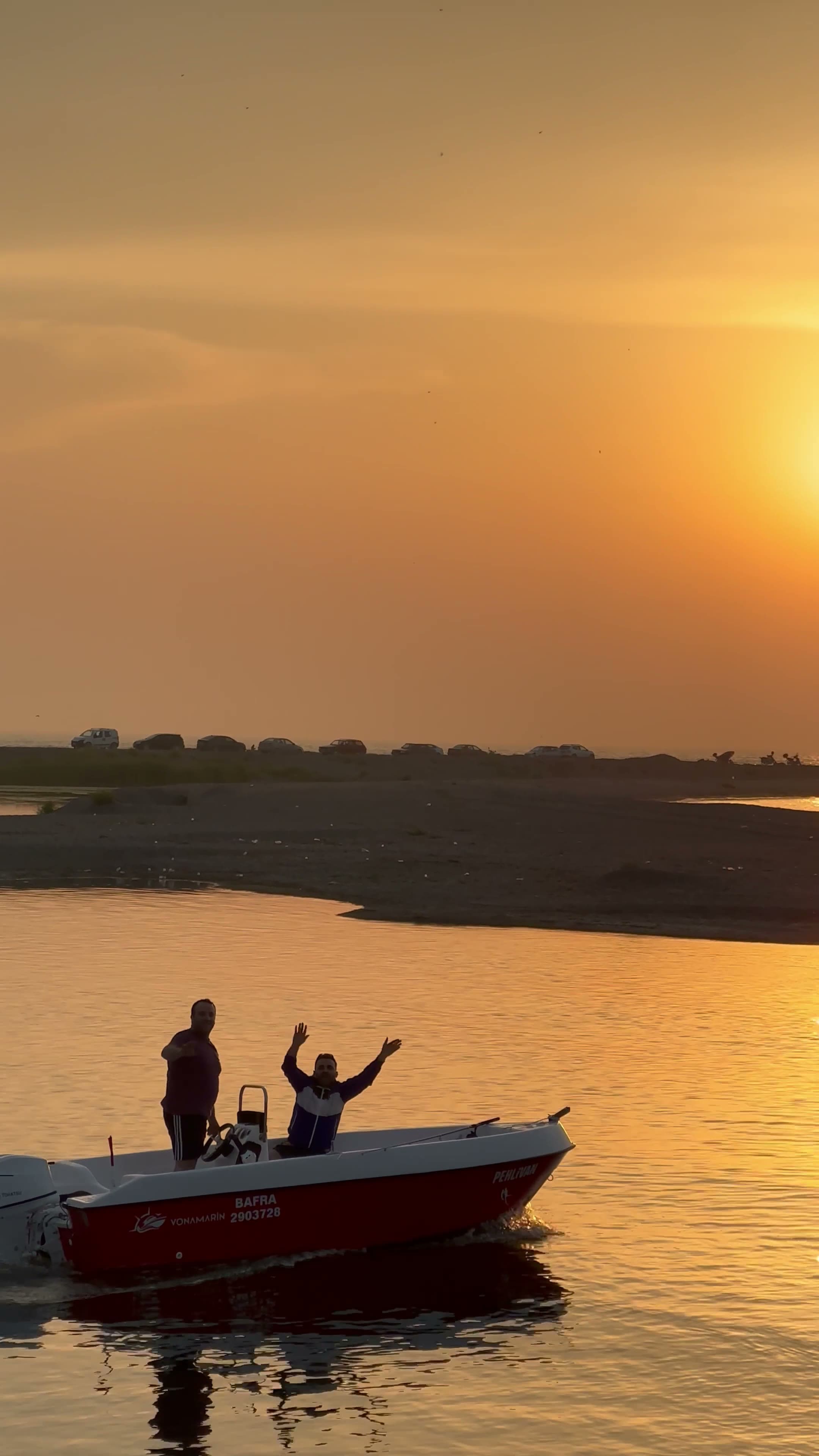 A motorboat cruising along the water at sunset