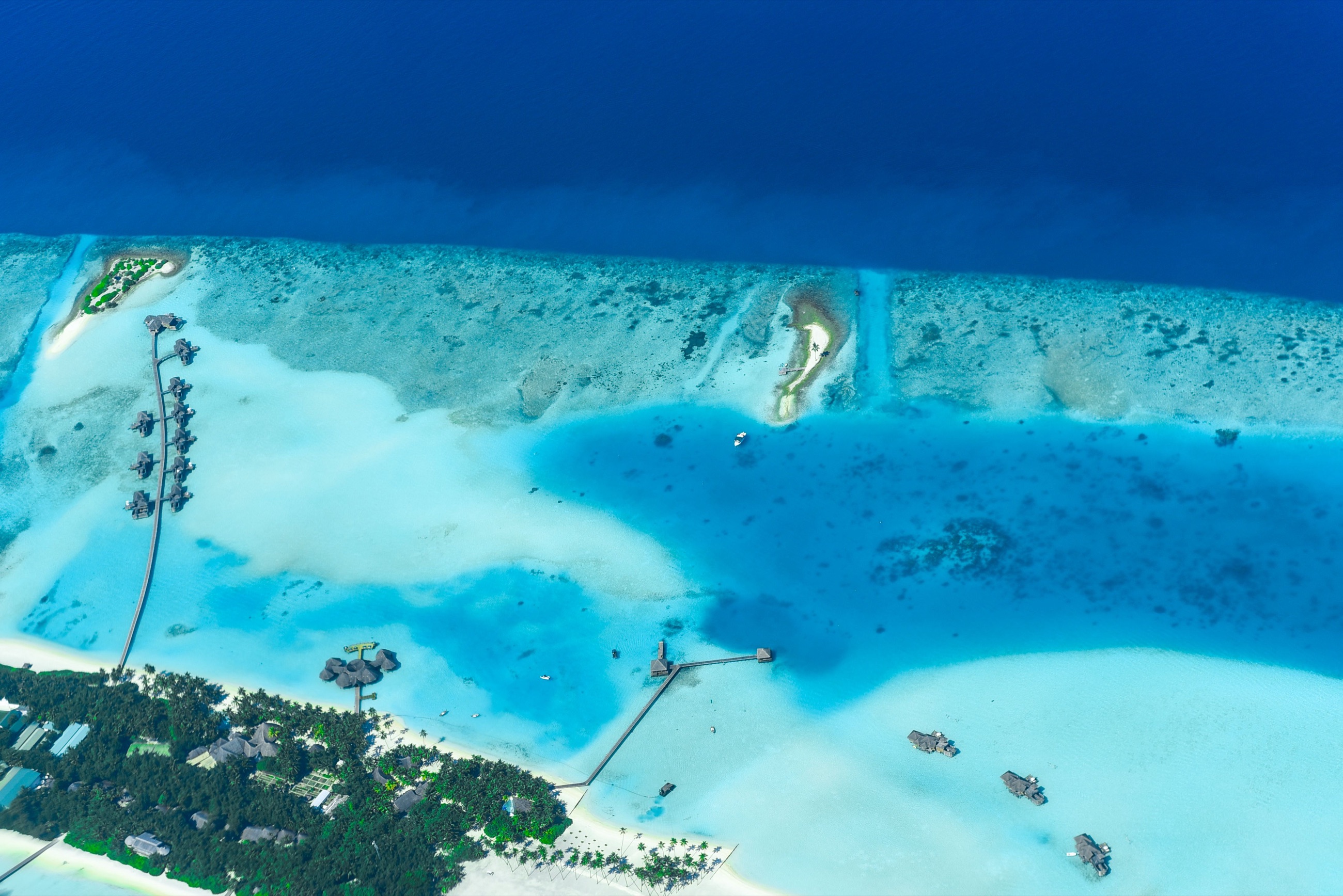 Overwater villas on stilts reaching out into a turquoise lagoon