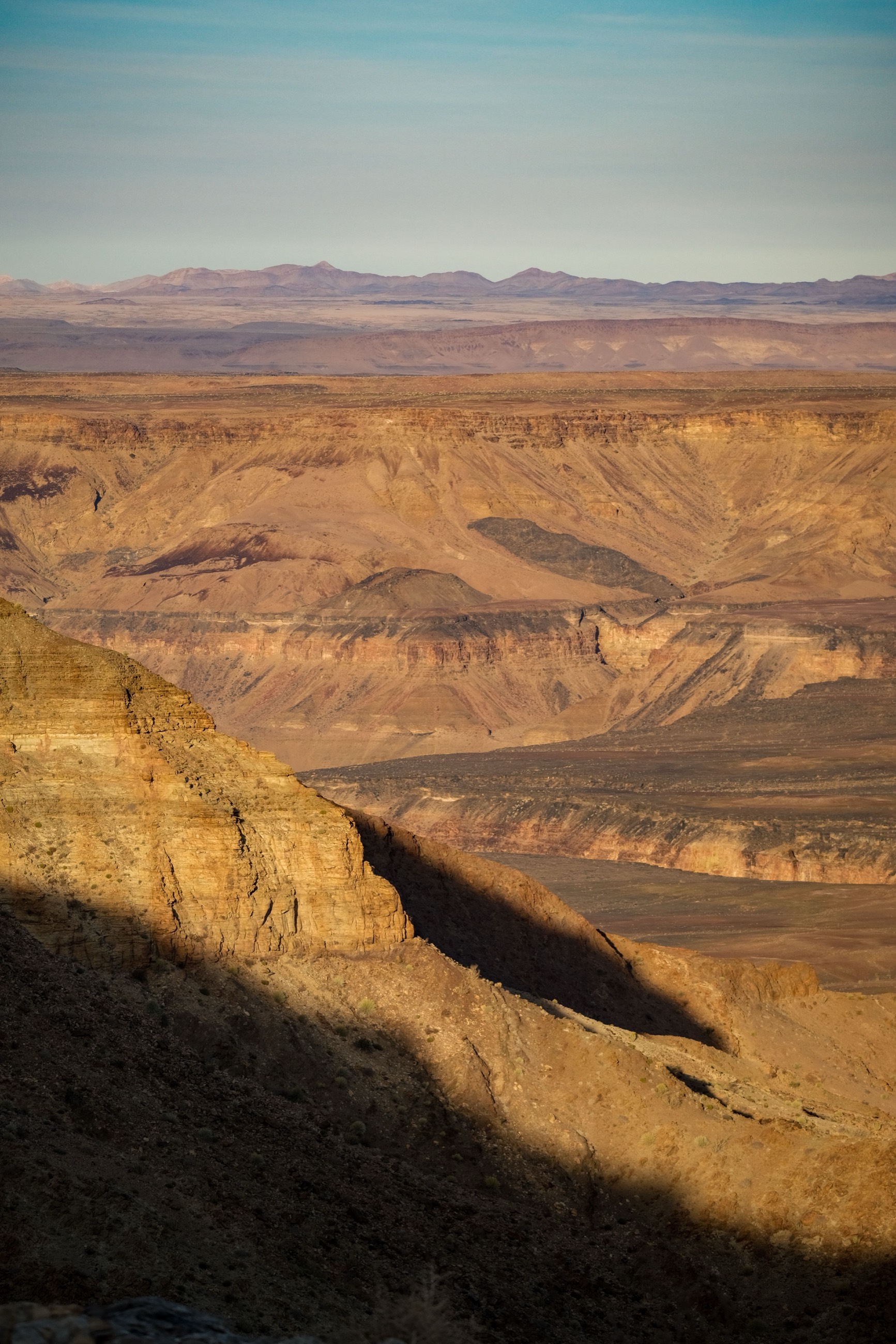 Layered rock walls of Fish River Canyon at golden hour