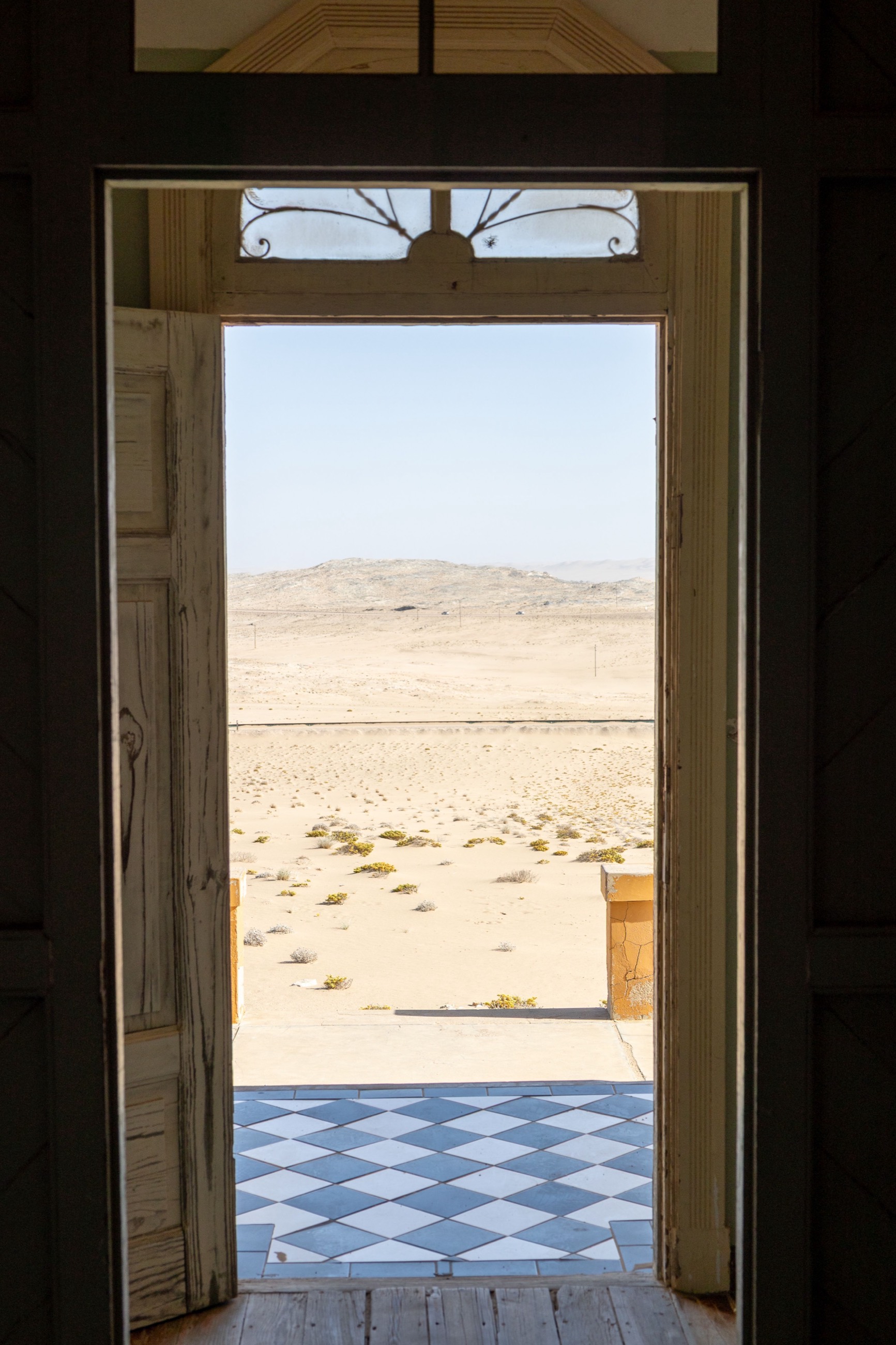 A doorway framing the desert beyond an abandoned Kolmanskop building